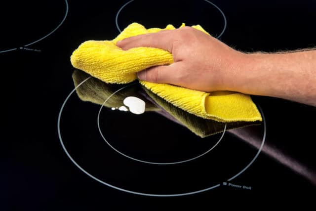 One of the tips for how to clean a cooktop is to wipe up spills before cooking.